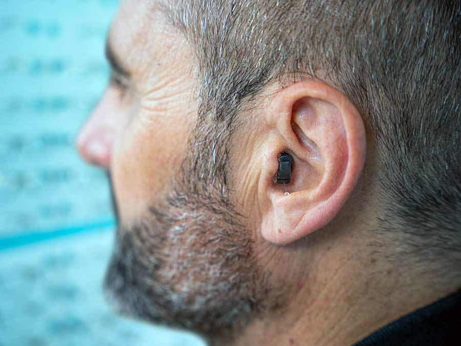 A man wears comfortable invisible hearing aids at Amplify Hearing